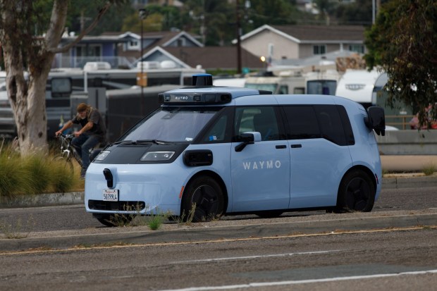 A Waymo Ojai drives along Tecolote Road in San Diego. (Kristian Carreon / The San Diego Union-Tribune)