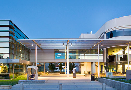 UC Davis Comprehensive Cancer Center, a metal and glass building, seen from the outside.