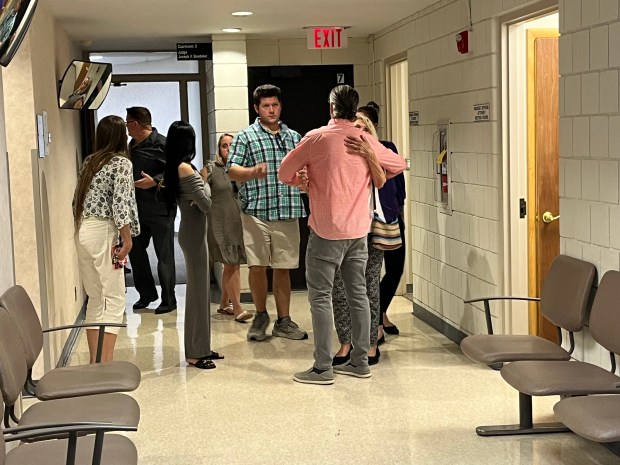 Two individuals embrace as family and friends of Julie Faithbruckner file out of an arraignment hearing Wednesday afternoon in 39th District Court. (MITCH HOTTS -- THE MACOMB DAILY)