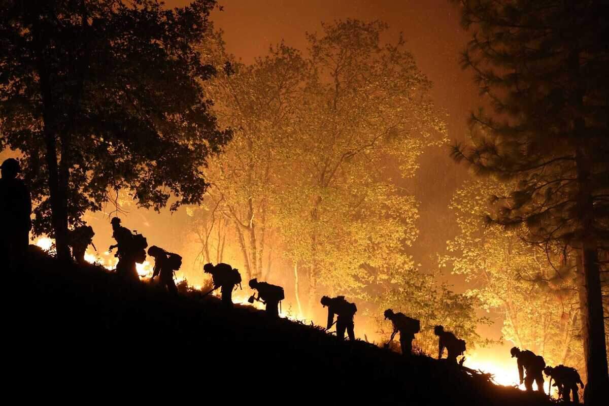 Firefighters are seen building containment lines against the leading edge of the Mosquito Fire in Placer County on Sunday, Sept. 11, 2022. The California Public Utilities Commission on Thursday handed a $22 million fine to the Pacific Gas and Electric Company for the 2022 wildfire.