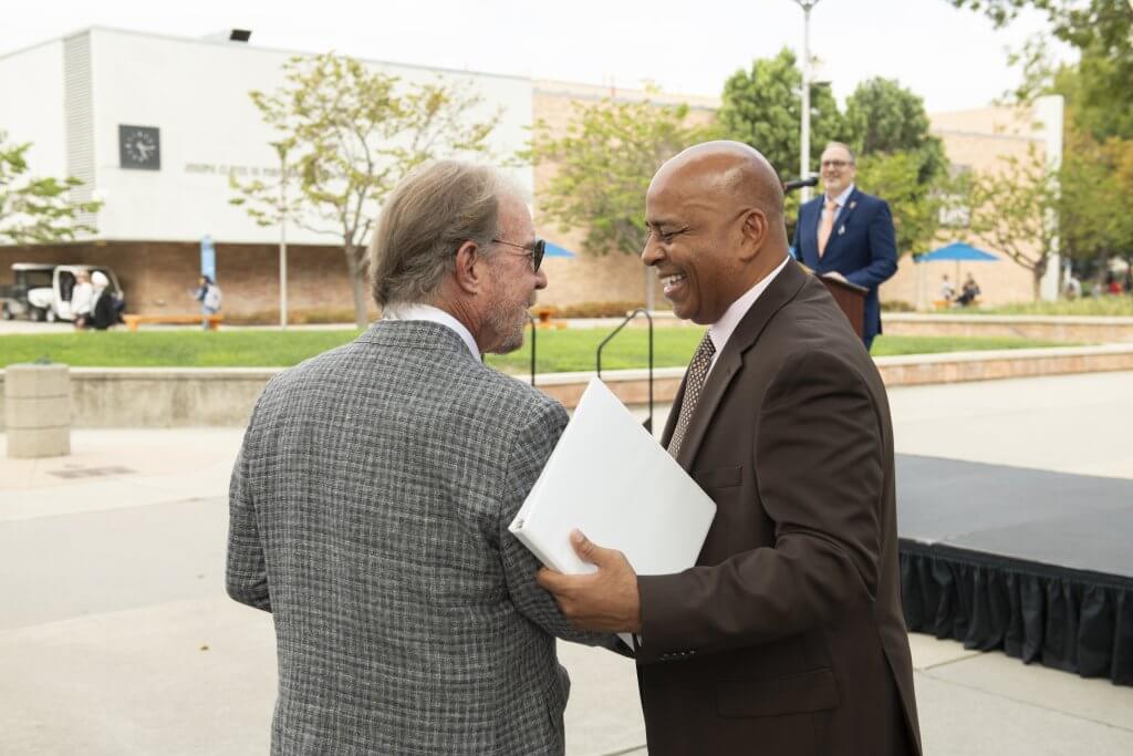 Scott O'Brien and Ronald Rochon shake hands at the Sept. 15 Titan statue dedication ceremony. 