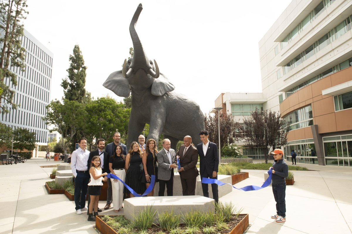 University supporters Scott and Deanna O’Brien join CSUF President Ronald Rochon and other campus community members to cut the ribbon in front of the Titan Statue.