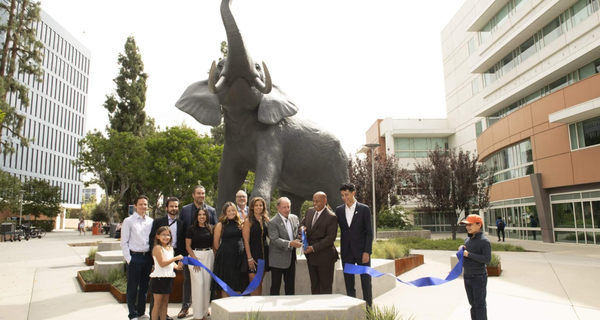 University supporters Scott and Deanna O’Brien join CSUF President Ronald Rochon and other campus community members to cut the ribbon in front of the Titan Statue.