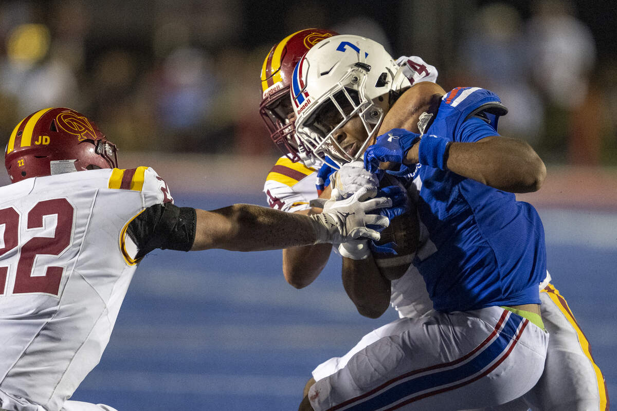 Folsom Bulldogs’ EJ Coleman is brought down by a Cardinal Newman defender in the first half in Folsom on Friday.