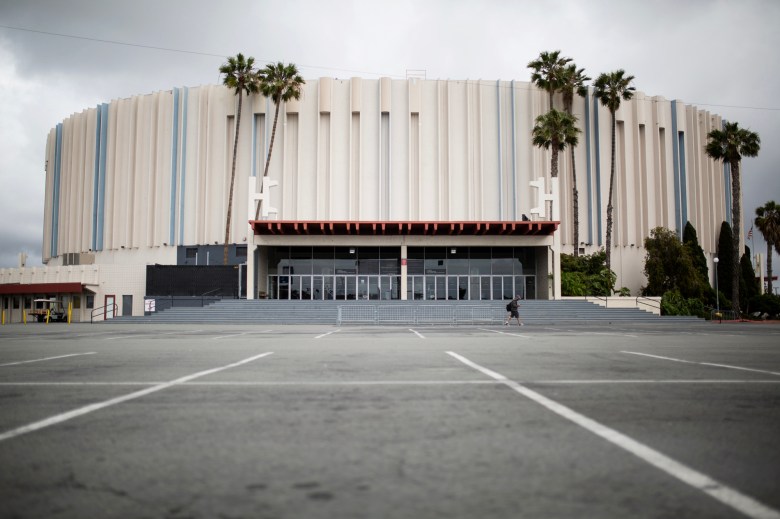 Pechanga Arena in San Diego stands behind an empty parking lot lined with palm trees.