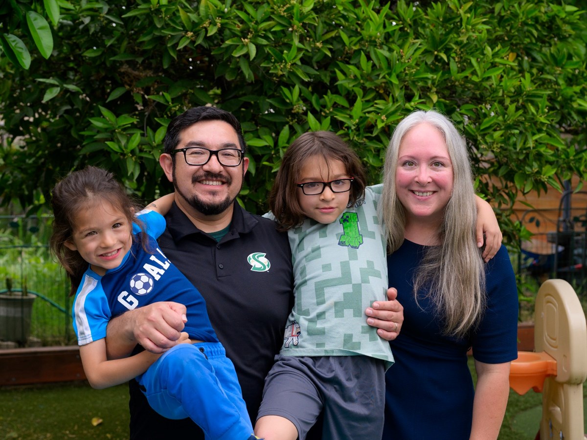 Eric Guerra poses for a family photo with his two children and wife.