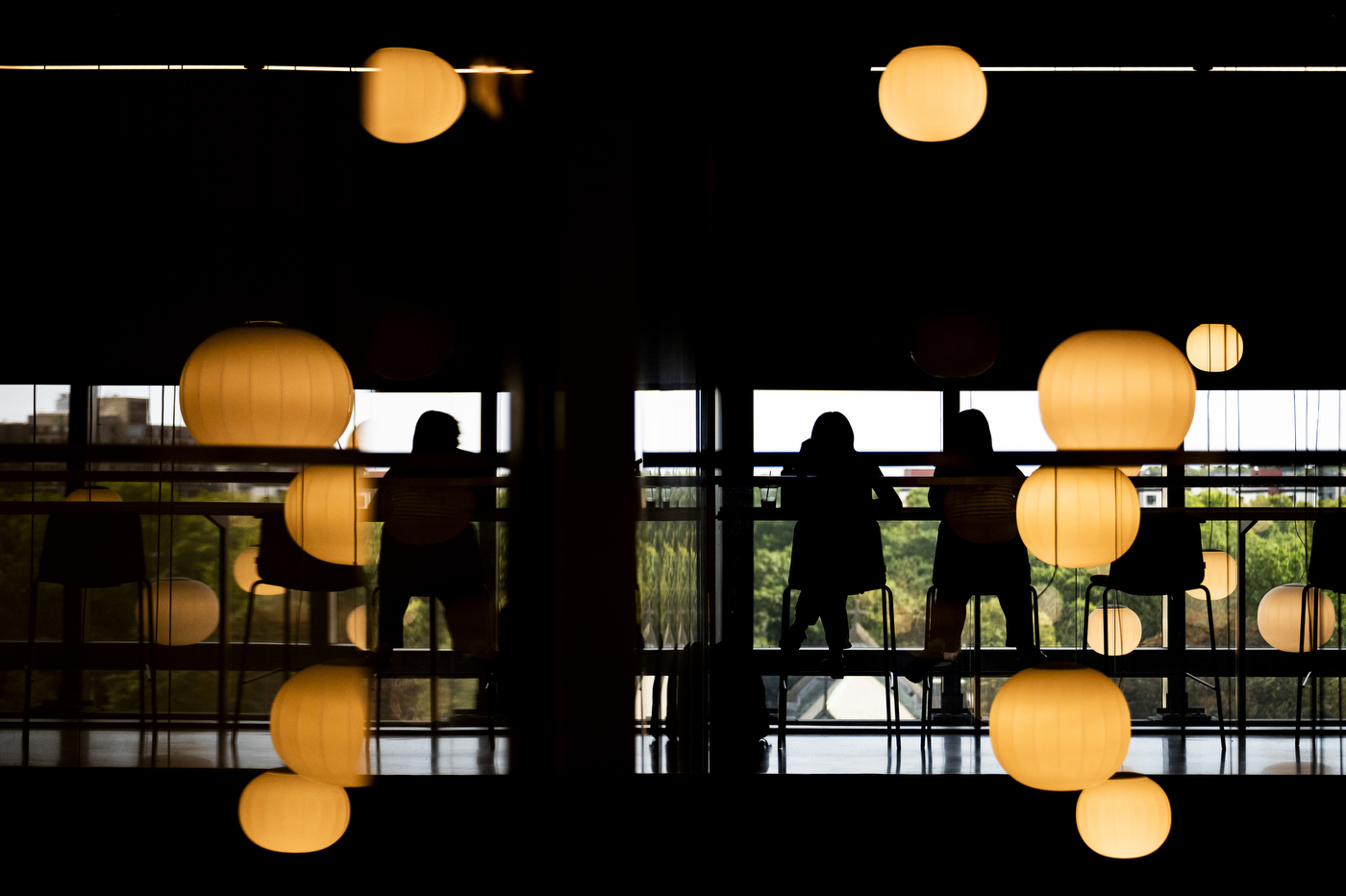 Students study inside the EXP building, silhouetted against paper lantern lights.