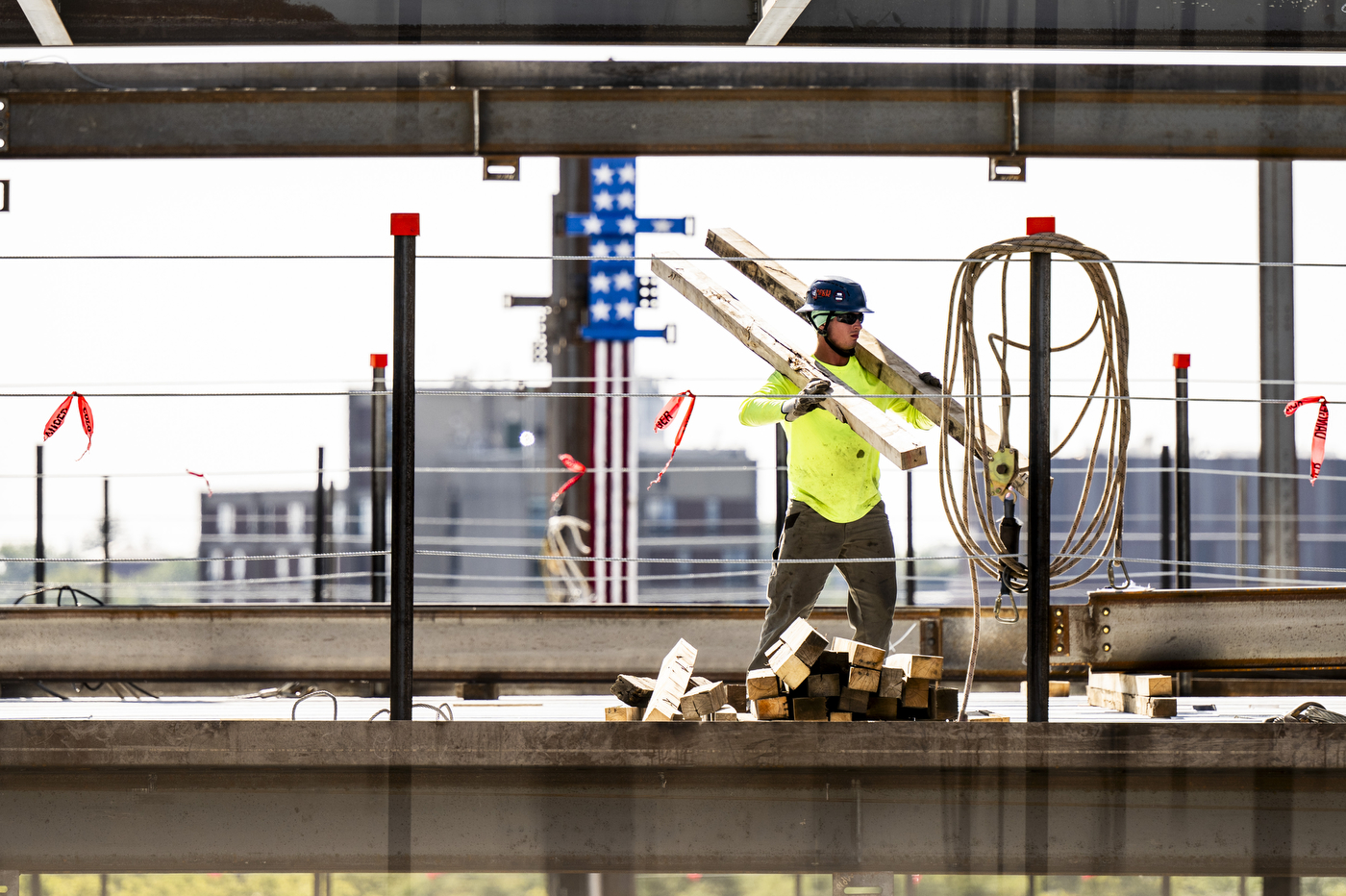 A construction worker carries lumber through a steel structural frame at the 840 Columbus Avenue construction site.