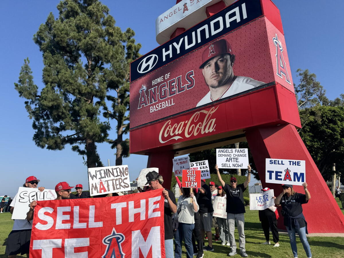 Angels fans wave signs and urge owner Arte Moreno to sell the team during a protest on Saturday at Angel Stadium.