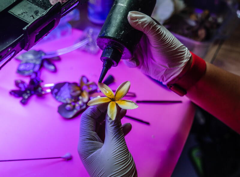 Vidanska applies resin to the flowers she grows at home, like plumeria and bougainvillea to make hair pins and other accessories.