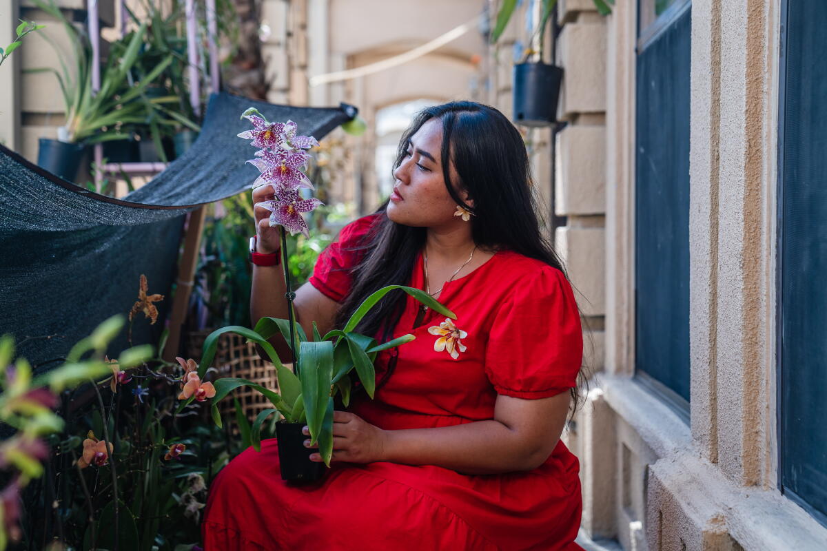 Artist Bunga Vidanska next to her orchid plants from different parts of the world