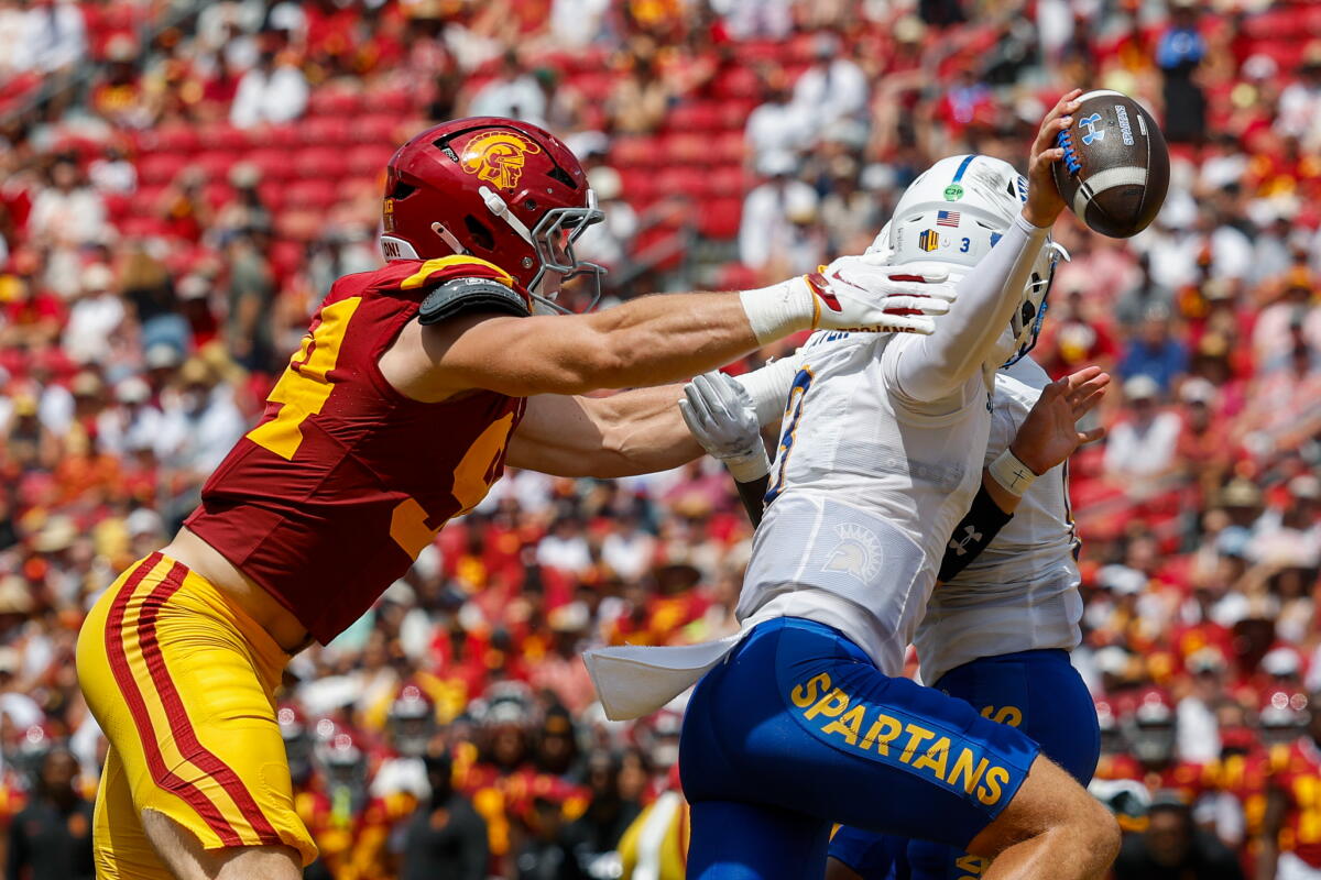 USC defensive end Luke Wafle, left, pressures San Jose State quarterback Luke Weaver, who tries to scramble away.