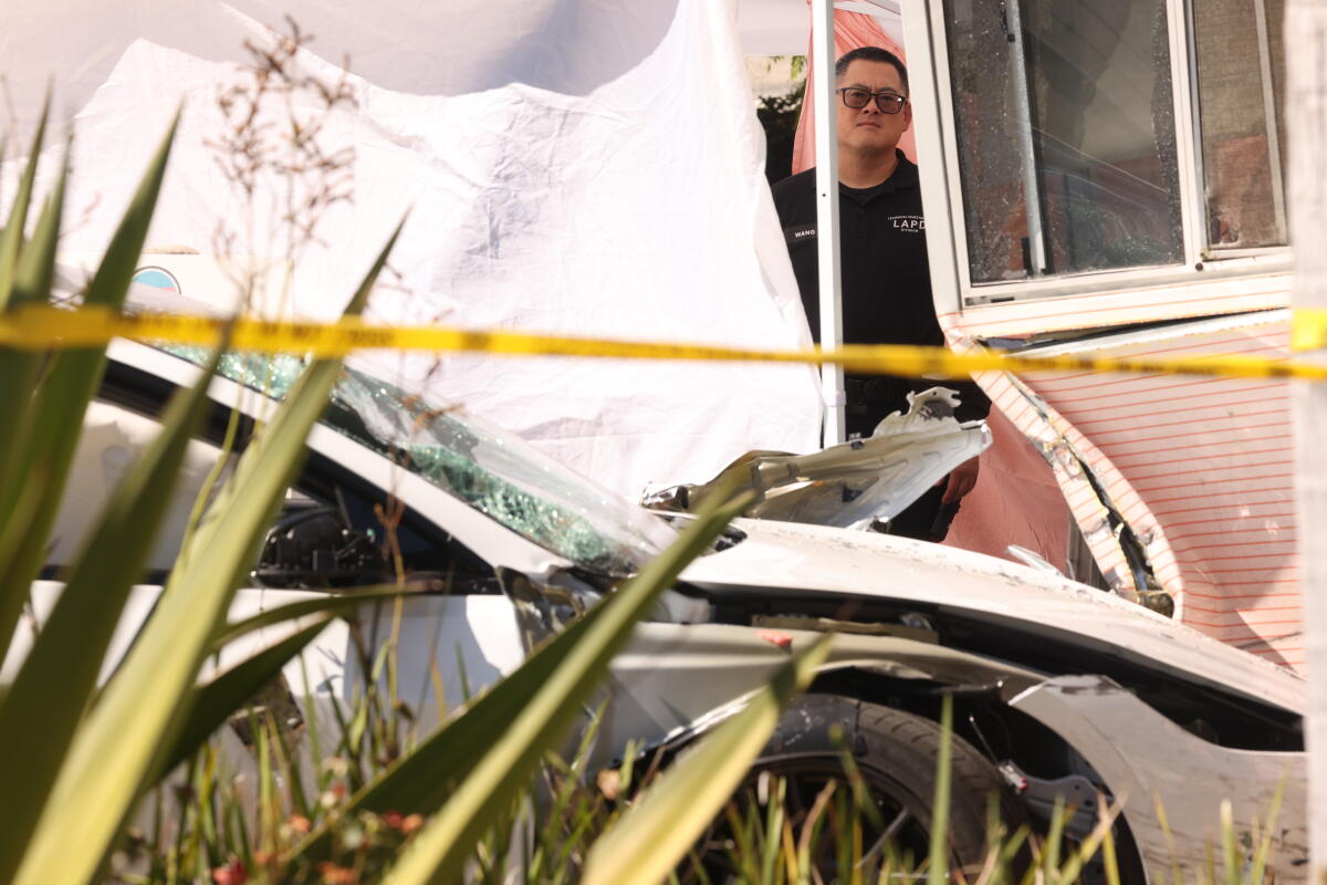 An LAPD officer responds to the scene of a car accident, seen in the foreground.