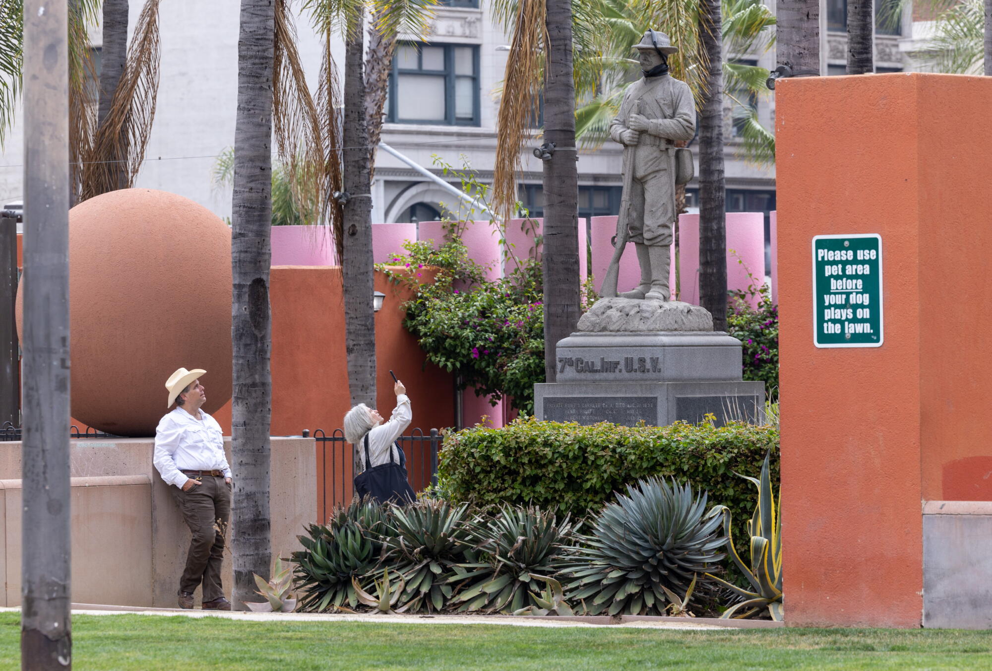 A woman takes a photographs in Pershing Square.