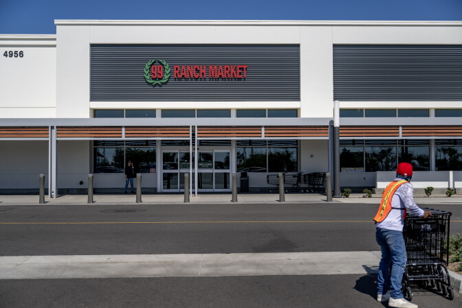 A store clerk gathers grocery carts outside a 99 Ranch supermarket 