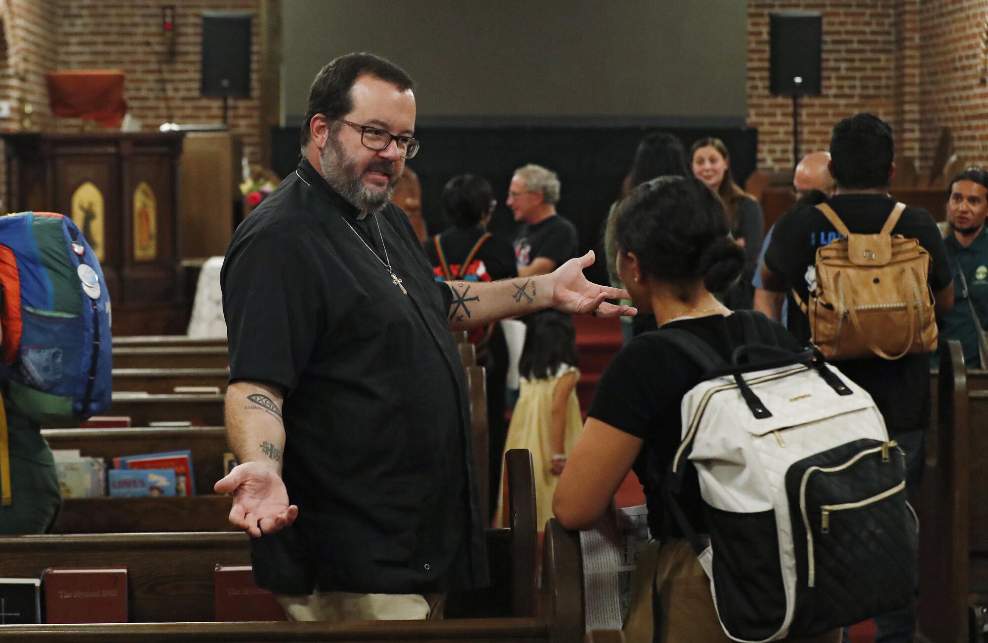 Priest Luke Martinez expresses concerns during the community meeting .