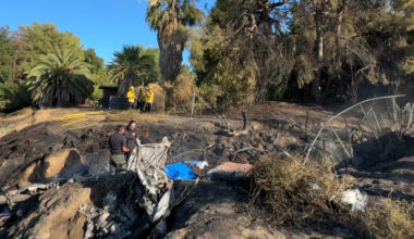 a river embankment with airplane wreckage and first responders