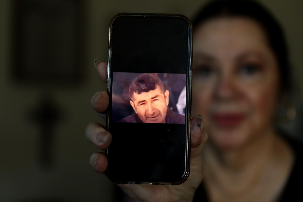 Vivian Lee Arguello holds a photo of her partner, Rafael Vela Gonzalez.