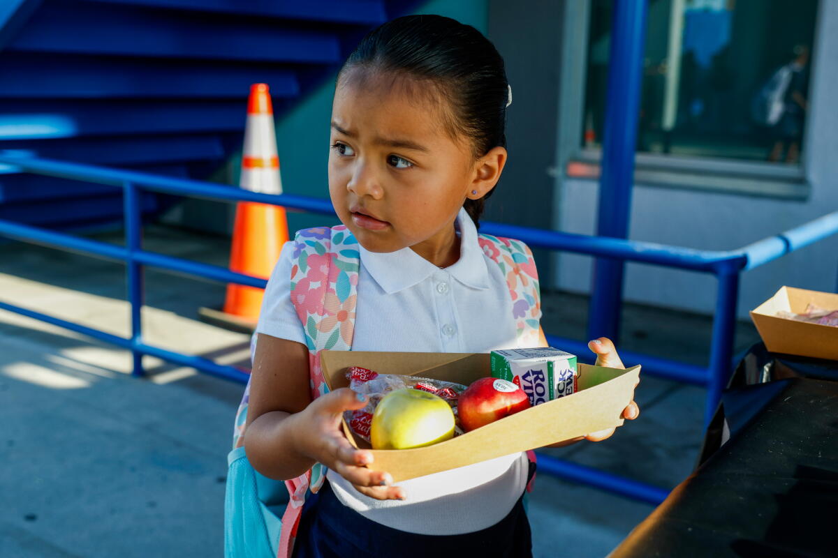 Kindergartner Gianna holds a breakfast meal on her first day of school.