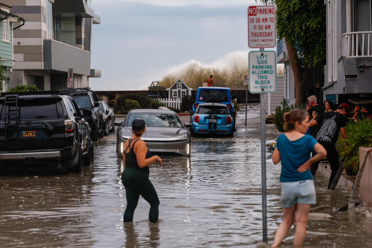 People and vehicles in a flooded street.