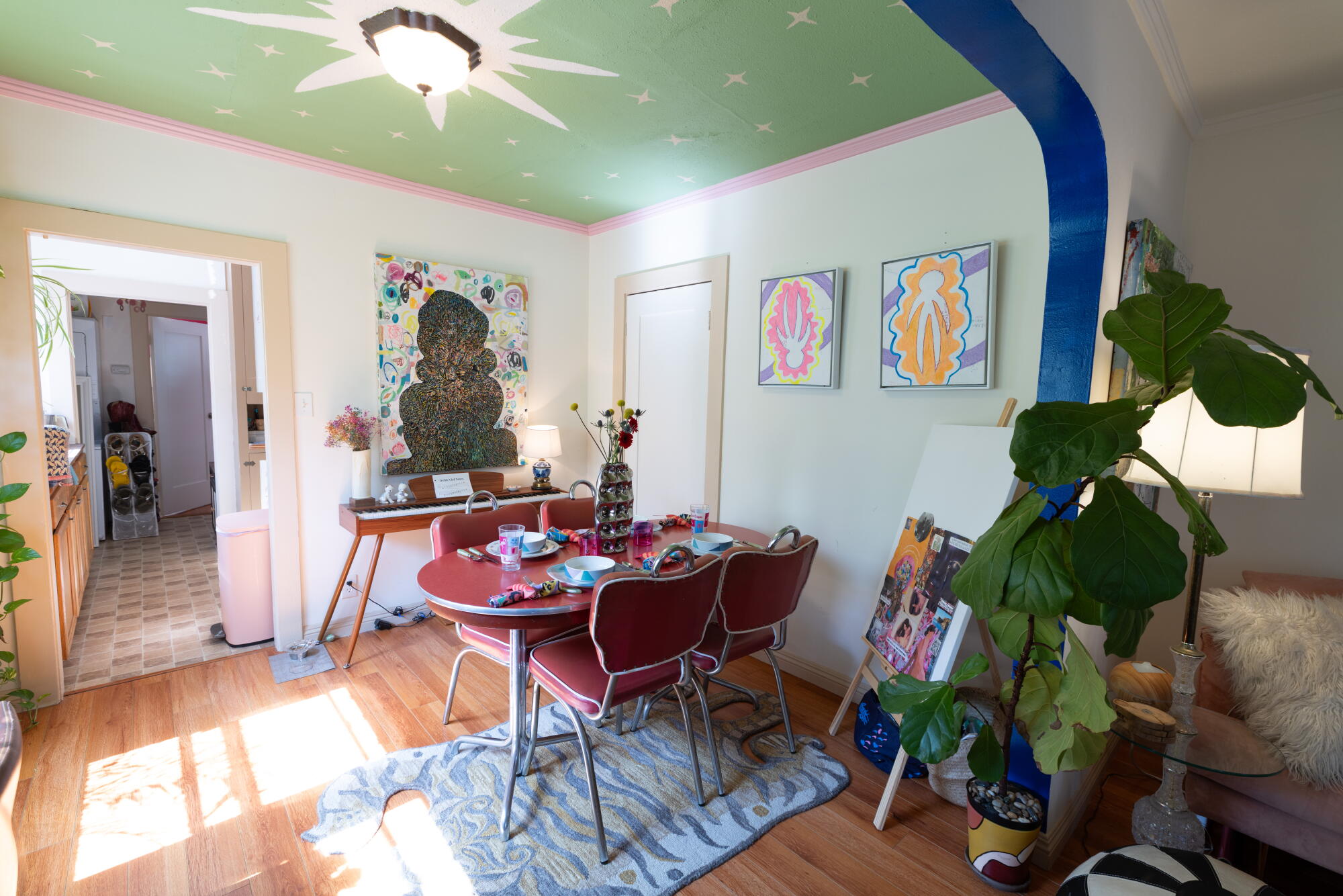 A dining area with colorful touches including wall art.