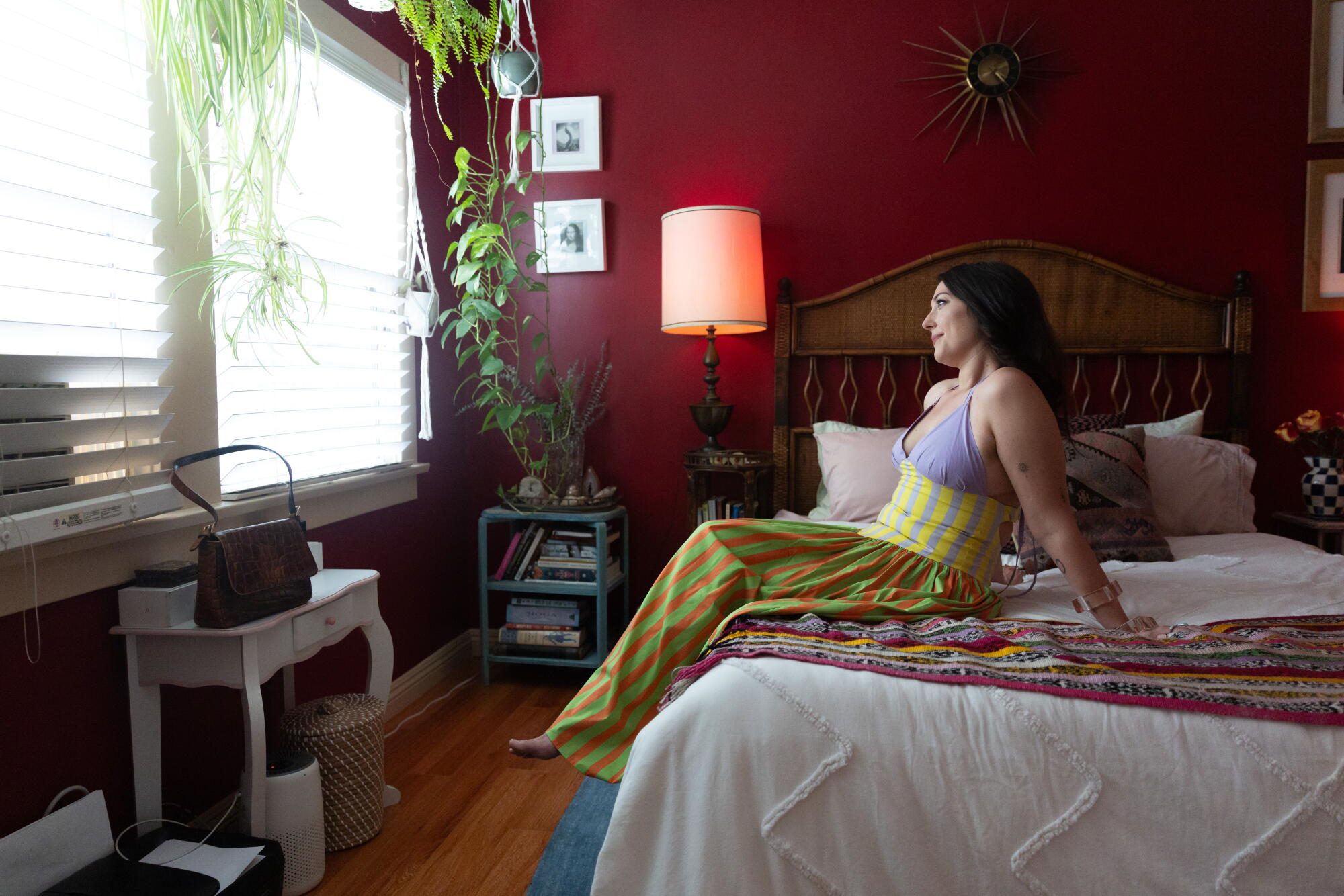 Morgan Jordan sits on her bed in her rental.