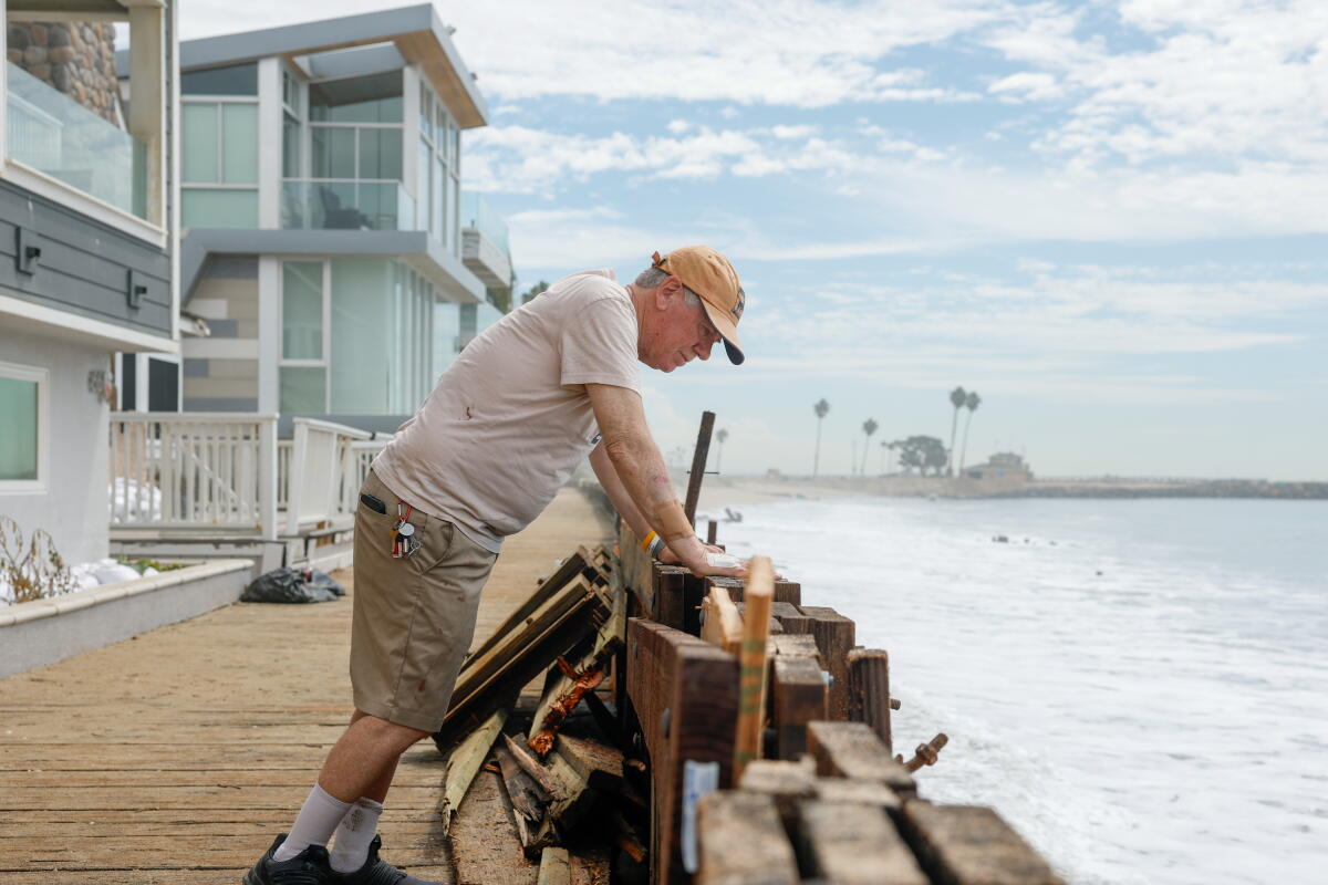 Local resident Ken Holt looks over the damaged sea wall outside of his home in on Long Beach's peninsula.