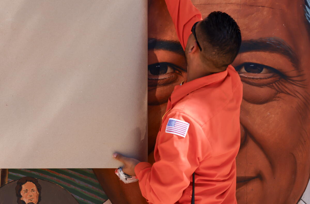Public Works for the City of San Fernando cover a mural at the Cesar E. Chavez Memorial Park