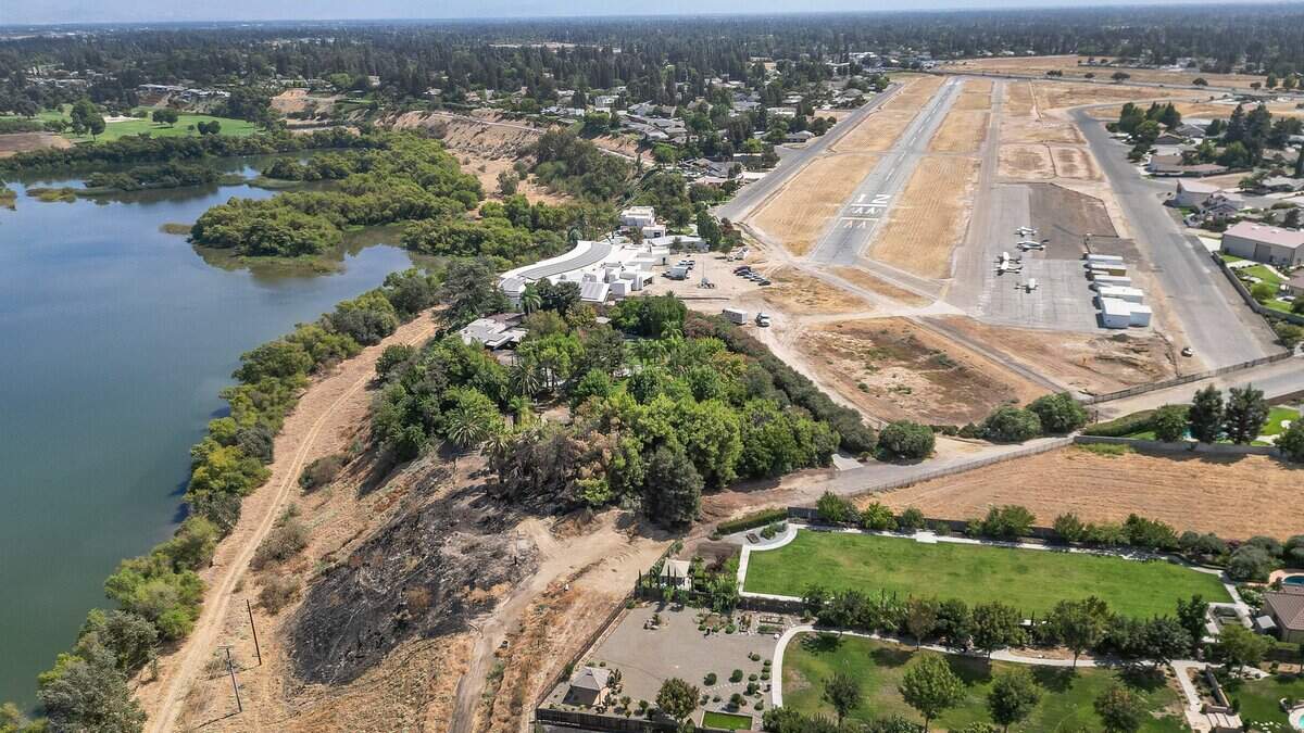 A blackened hillside, lower left, between Milburn Pond and the Sierra Sky Park Airport in northwest Fresno shows where a vegetation fire was started after a plane crashed near the airport on Saturday, killing the four occupants aboard. Sierra Sky Park, photographed on Tuesday, Sept. 8, 2026, is described as the world's first residential fly-in aviation community