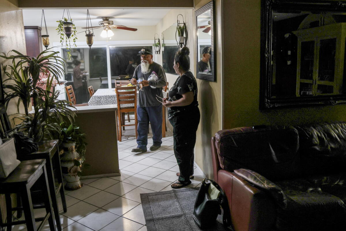 Salomon Olea gets ready for work in the kitchen of his home with his wife Maria
