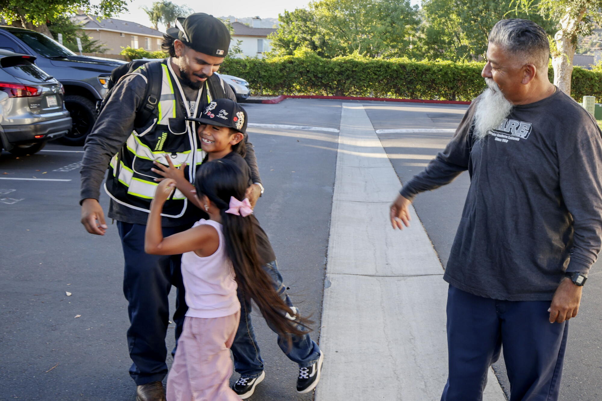 Angel Olea hugs his kids Ruby and Isaac while his dad, Salomon, looks on