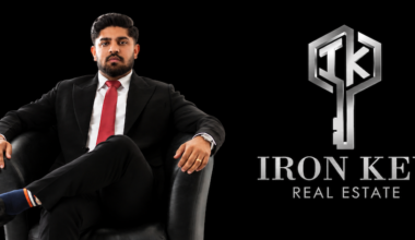Lovepreet Chandi of Iron Key Real Estate seated beside the company’s logo.