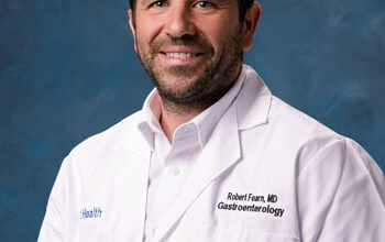 uci health gastroenterologist dr. robert fearn wearing a white coat in front of a blue studio background