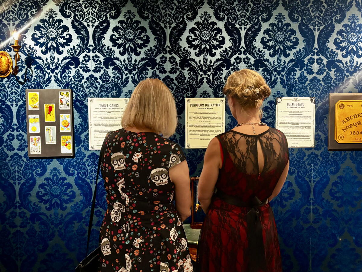Attendees read about tarot cards and the ouija board at Final Rites at Fullerton Museum.