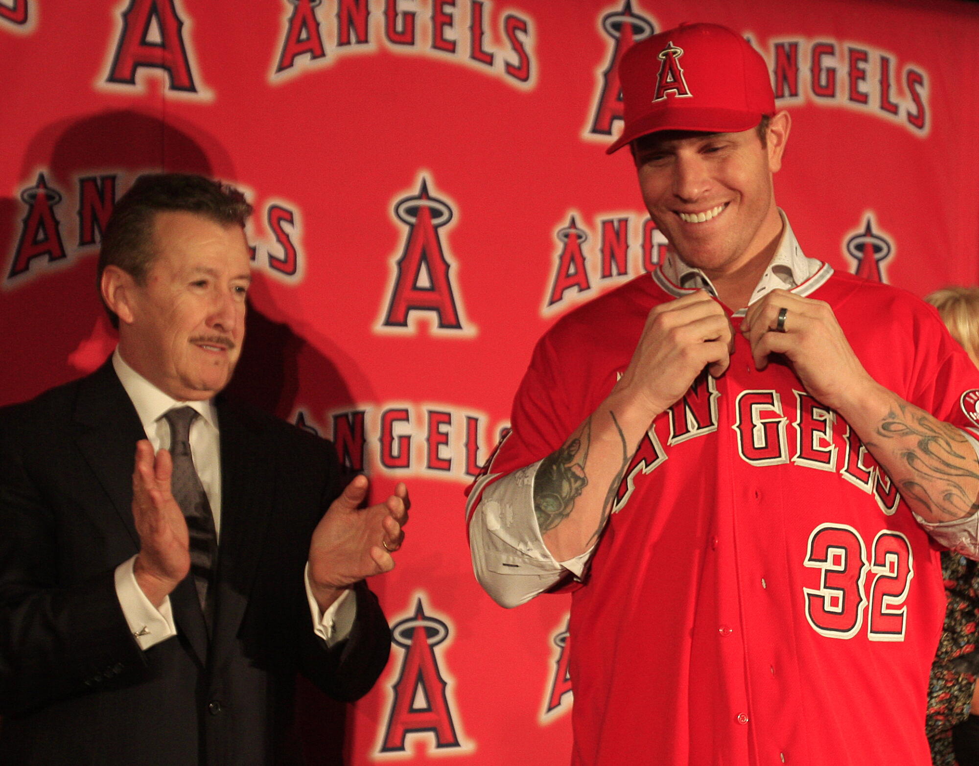 Angels owner Arte Moreno, left, cheers on his newest signing, outfielder Josh Hamilton, as he puts on his Angels jersey 