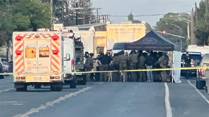 SWAT personnel gather near a Fresno residence Monday evening where police say a wanted person is refusing to come outside (PHOTO: Courtesy FOX26 Photojournalist John Dwelle.)