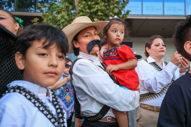 Edgar Franco, 8, left, Lorena Dominguez, and her 2-year-old daughter, Maya Alvarado, all of San Jose, look on as attendees dressed in patriotic colors and costumes dance to Mexican music before "El Grito," or "The Cry," delivered by Consul General Neftali Said Pérez González during the 216th anniversary of Mexican Independence Day celebrations at San Jose City Hall during the 216th anniversary of Mexican Independence Day celebrations at San Jose City Hall in San Jose, Calif., on Tuesday, Sept. 15, 2026. (Ray Chavez/Bay Area News Group)