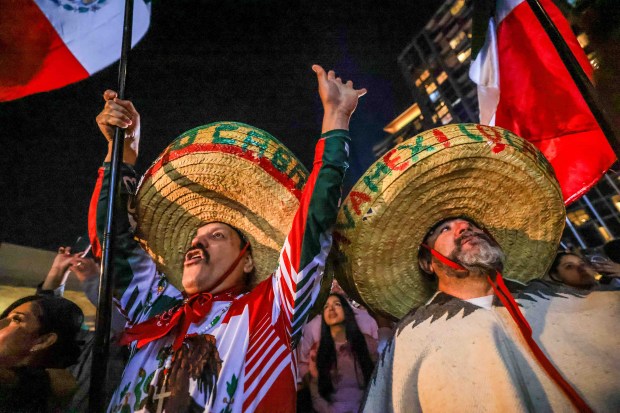 Fernando Robles, left, and, Alvaro Cortez, of San Jose, wave the Mexican flags as Consul General Neftali Said Pérez González delivers "El Grito," or "The Cry," during 216th anniversary Mexican Independence Day celebrations at San Jose City Hall in San Jose, Calif., on Tuesday, Sept. 15, 2026. (Ray Chavez/Bay Area News Group)