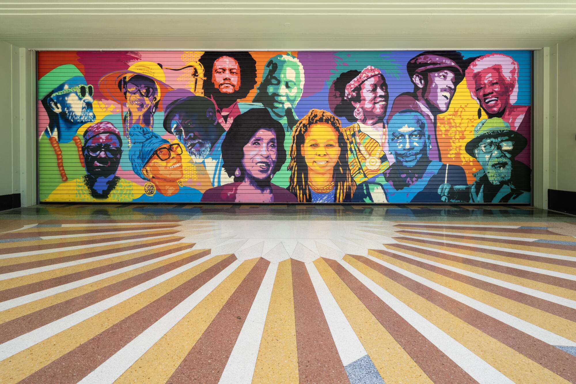 Vision Theatre in Leimert Park features a colorful mural of faces by artist Sei Shimura titled "Leimert Park Cultural Icons."