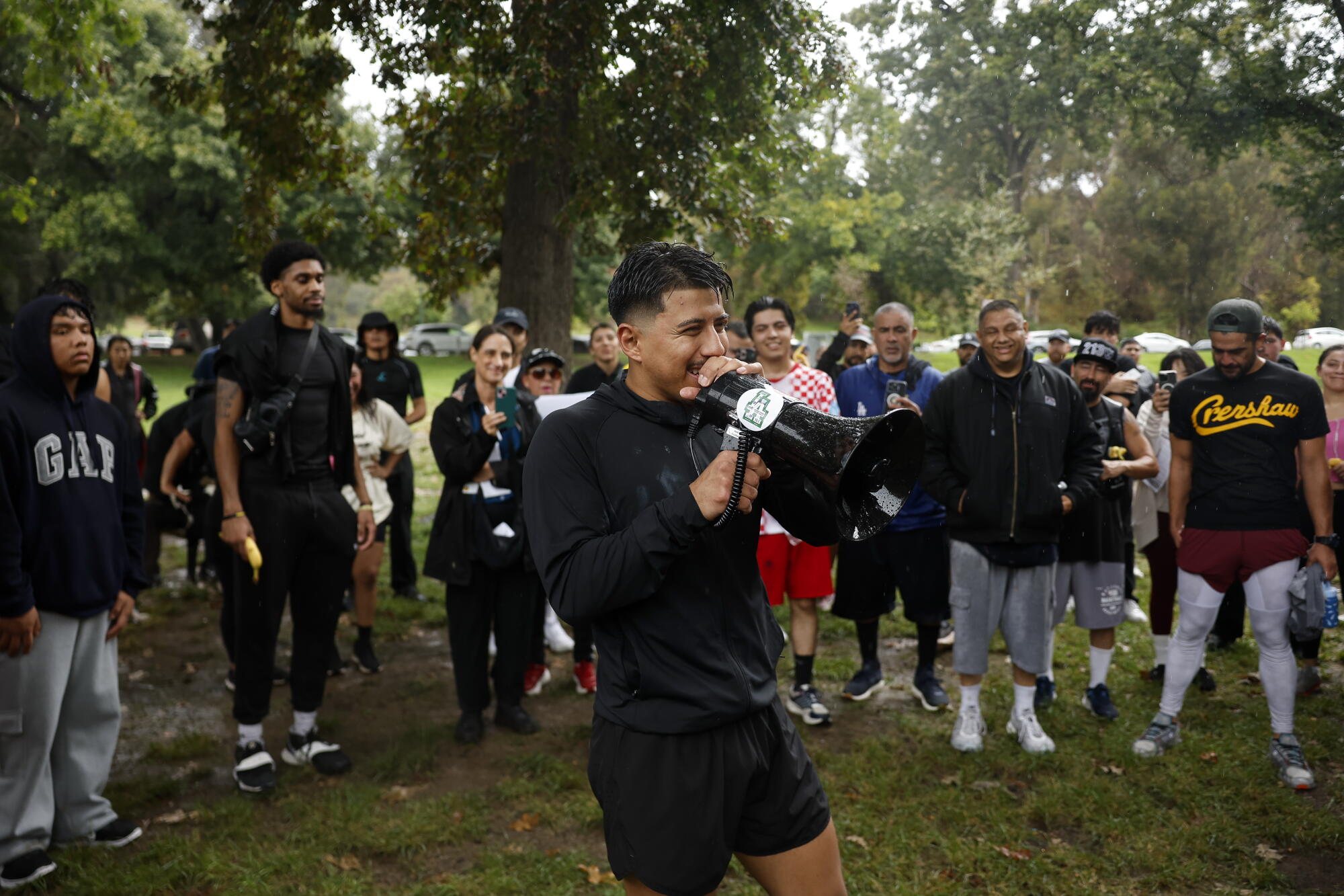 A man with a megaphone speaks to participants after the run in Elysian Park.
