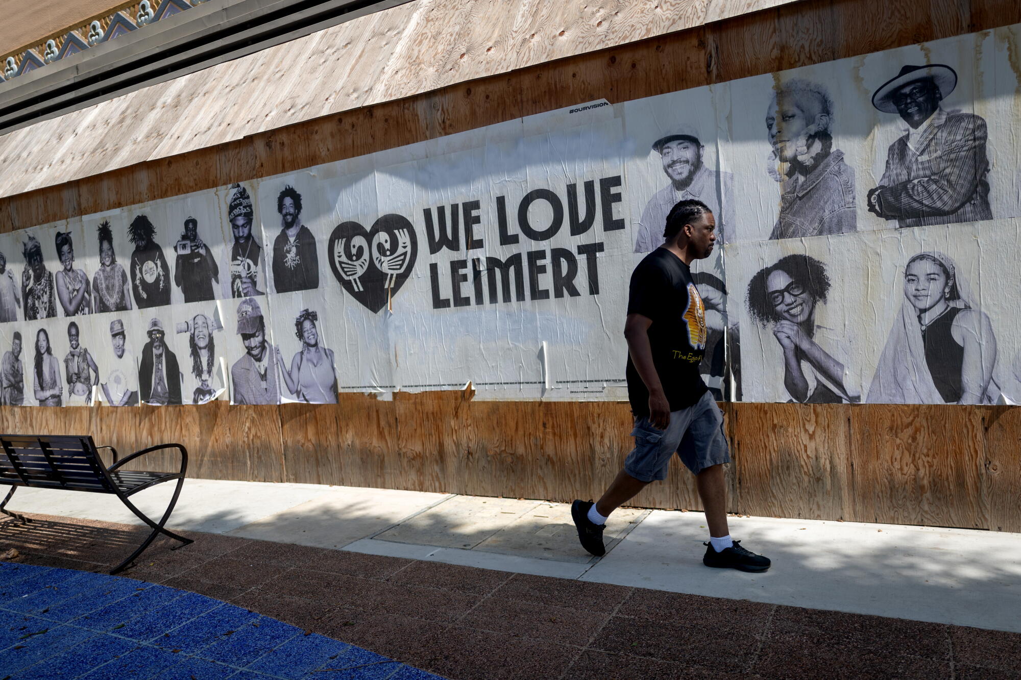 A man walks past a mural during a weekly African Marketplace & Drum Circle and vendor market in the Leimert Park.