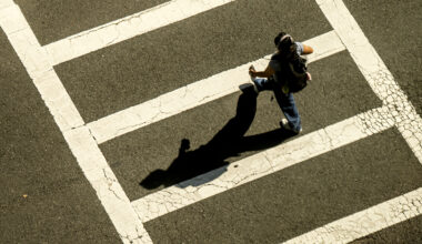 A student walks across a crosswalk.