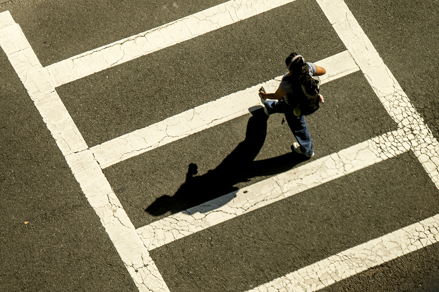 A student walks across a crosswalk.