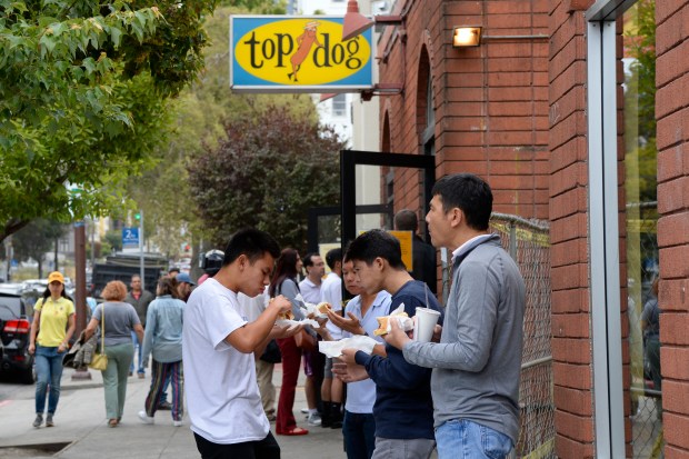 Customers enjoy eating hot dogs from Top Dog in Berkeley in 2017. (Jose Carlos Fajardo/Bay Area News Group)