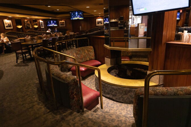 A dimly lit lounge, with diners eating at booths in the background.