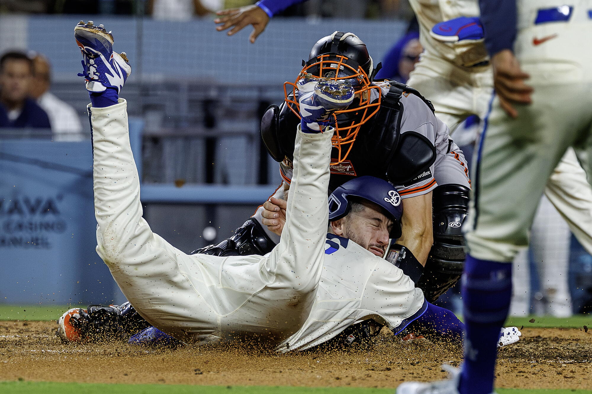 Dodgers baserunner Kyle Tucker slides head first into Giants catcher Andrew Knizner while scoring a run.