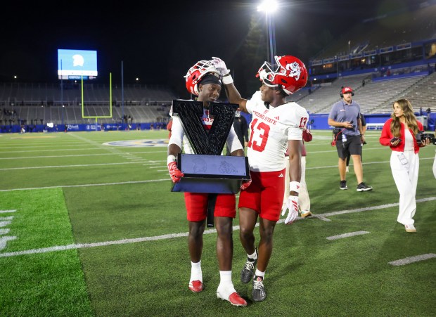 Fresno State Bulldogs' Camrin Cole (13) and Fresno State Bulldogs' Loyall Mouzon (7) carry the Valley Trophy off the field after Fresno State wins against San Jose State Spartans at CEFCU Stadium in San Jose, Calif., on Saturday, Sept. 19, 2026.  (Shae Hammond/Bay Area News Group)