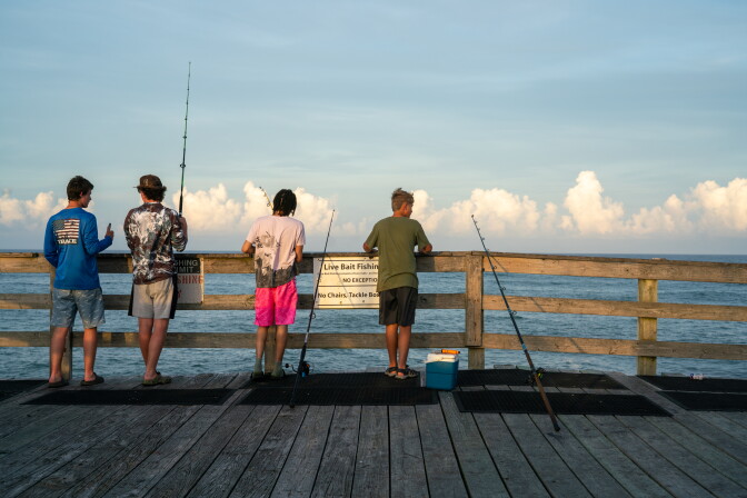 People fish off the pier.