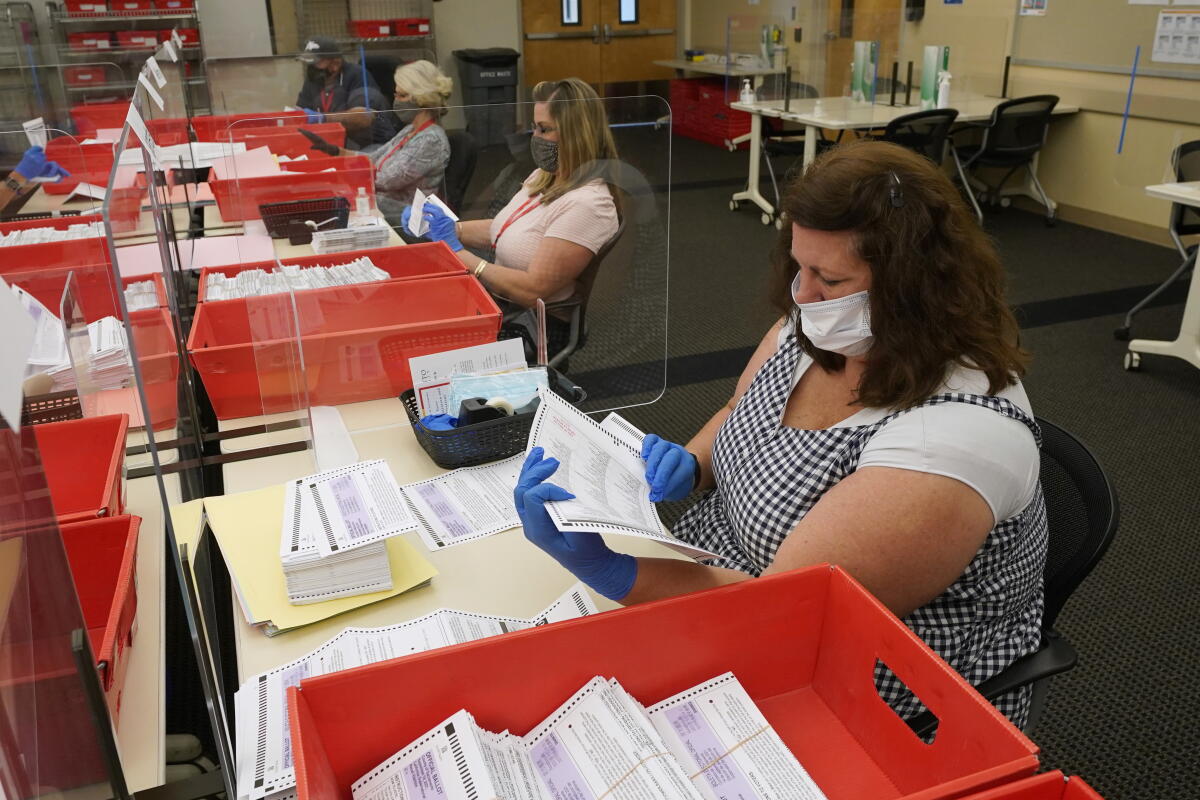 Election workers inspect ballots at the Sacramento County Registrar of Voters office in Sacramento, Calif., Aug. 30, 2021.
