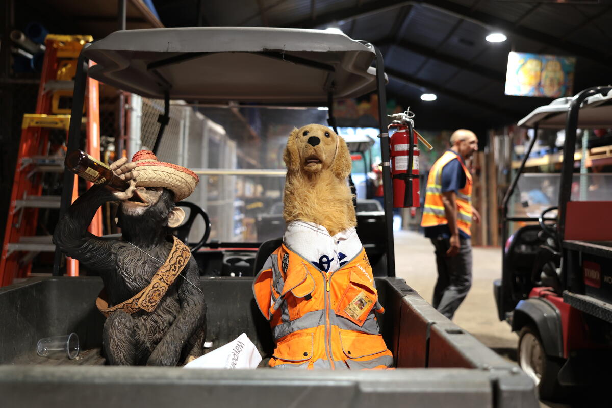 A ceramic dog and monkey sit on a golf cart inside the Dodger Stadium landscape team's shed on Tuesday.